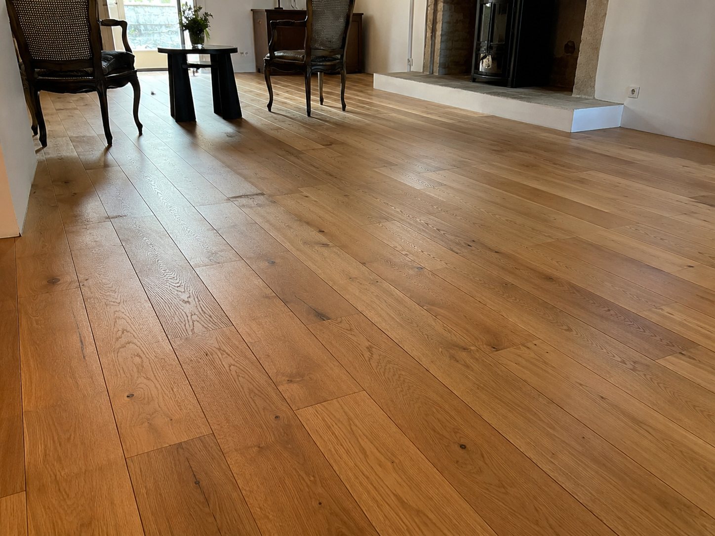 Parquet chêne massif large lames vitrifiées — salon avec cheminée en pierre